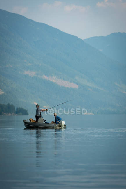 Dos pescadores pescando en el río en un día soleado - foto de stock