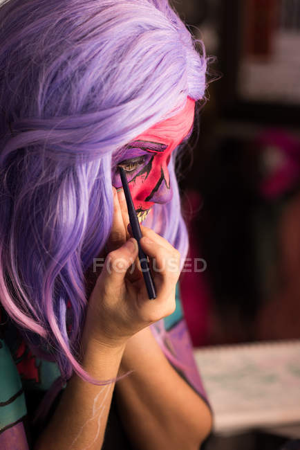 Mulher aplicando kajal para a celebração do dia das bruxas — Fotografia de Stock