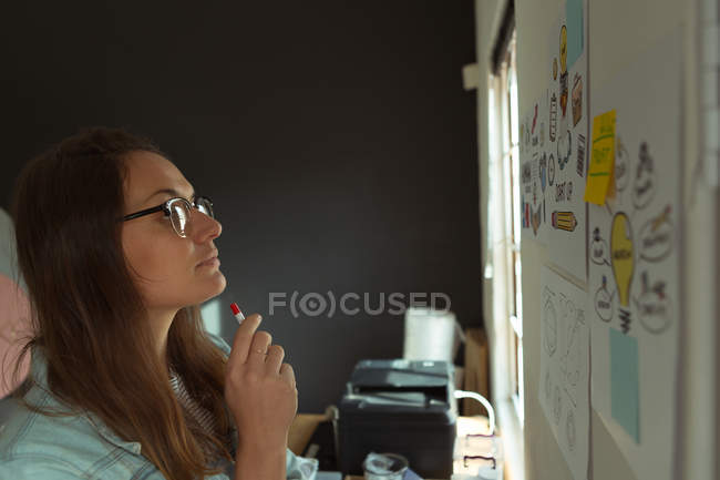 Thoughtful jewelry designer looking at chart in home — Stock Photo