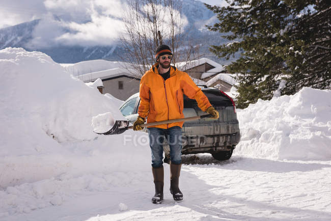 Чоловік прибирає сніг зі сніжною лопатою взимку — стокове фото
