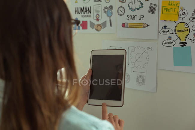 Rear view of jewelry designer using digital tablet at home — Stock Photo