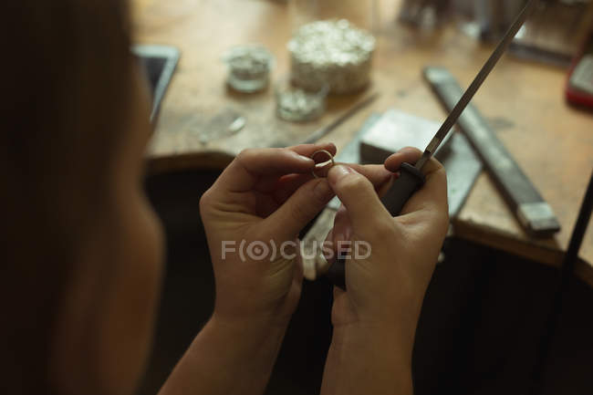 Female jewelry designer making ring in workshop — Stock Photo
