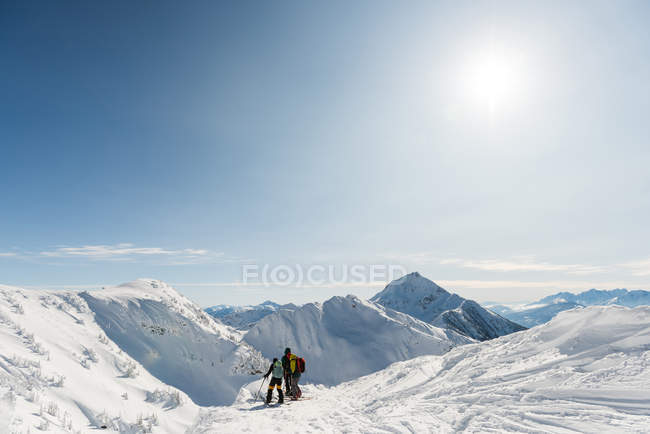 Groupe de skieurs marchant sur une montagne enneigée en hiver — Photo de stock