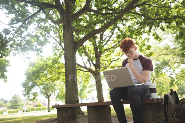 Внимательный студент колледжа использует ноутбук в кампусе — стоковое фото