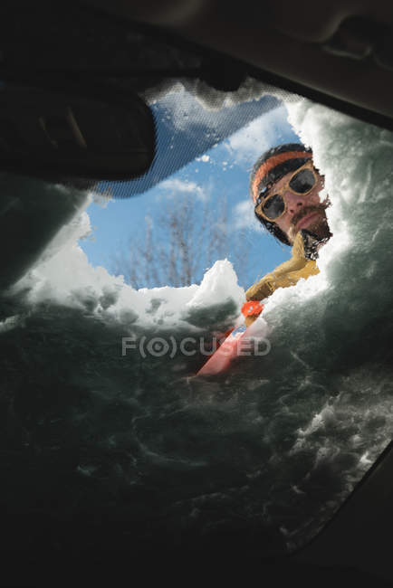 Mann räumt im Winter Schnee von Autoscheibe — Stockfoto