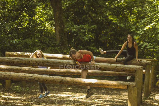 Ajuste o treinamento das mulheres sobre o curso de obstáculo no campo de treinamento — Fotografia de Stock