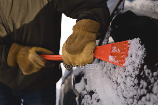 Sezione centrale dell'uomo pulizia neve dal parabrezza dell'auto durante l'inverno — Foto stock