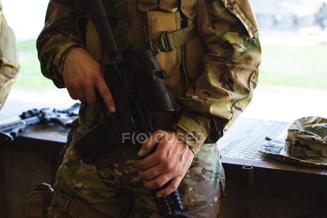 Parte média do soldado militar em pé com espingarda durante o treinamento militar — Fotografia de Stock