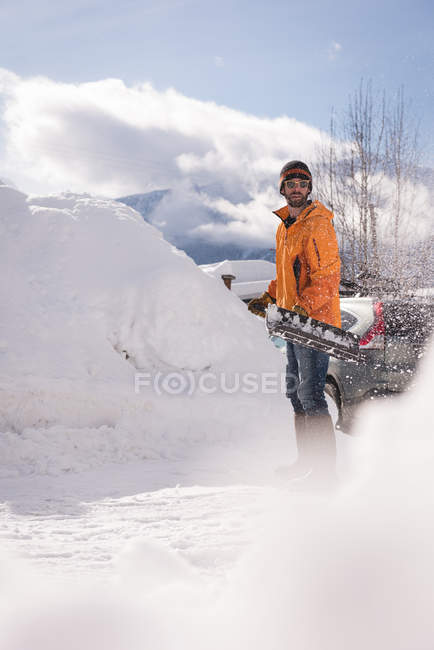 Mann räumt im Winter Schnee mit Schneeschaufel — Stockfoto
