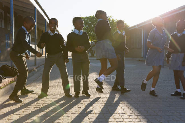 Studenti che si divertono nel campus scolastico in una giornata di sole — Foto stock