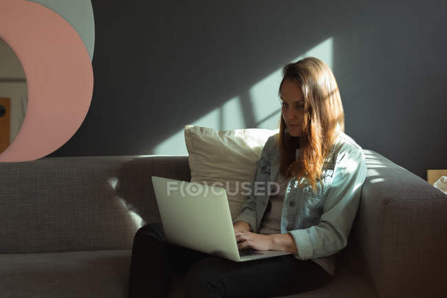 Female jewelry designer using laptop at home — Stock Photo