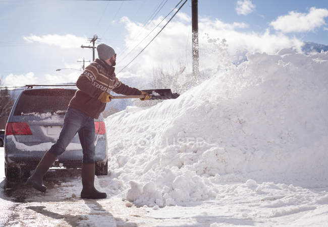 Man cleaning snow with snow shovel during winter — Stock Photo
