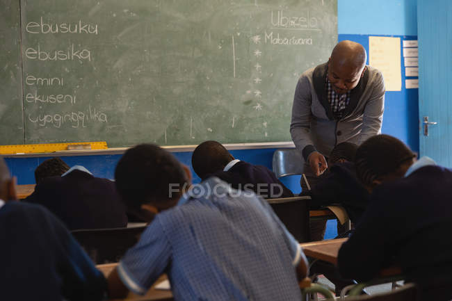 Male teacher teaching students in the class at school — Stock Photo