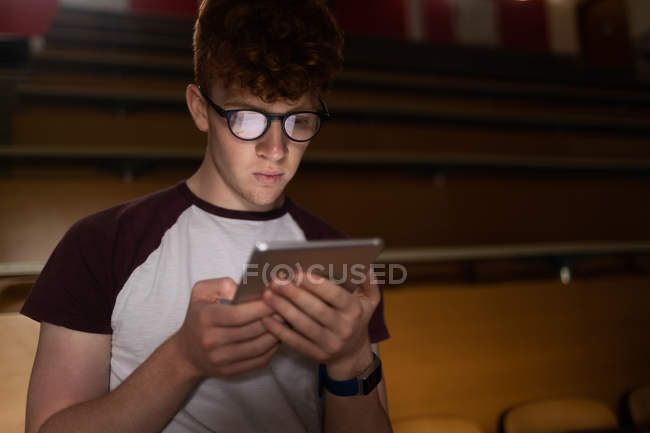 Молодой студент колледжа с помощью цифрового планшета в классе — стоковое фото