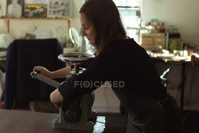 Schmuckdesignerin mit Maschine in Werkstatt — Stockfoto