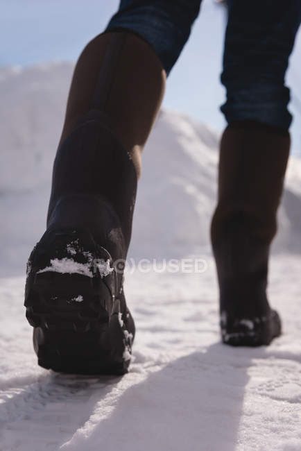 Low section of man walking on a snowy region — Stock Photo