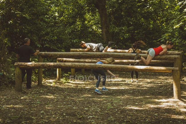 Encaixe o treinamento dos povos sobre o curso de obstáculo no acampamento da bota — Fotografia de Stock