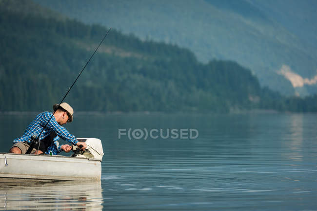 Pescador pesca no rio em um dia ensolarado — Fotografia de Stock