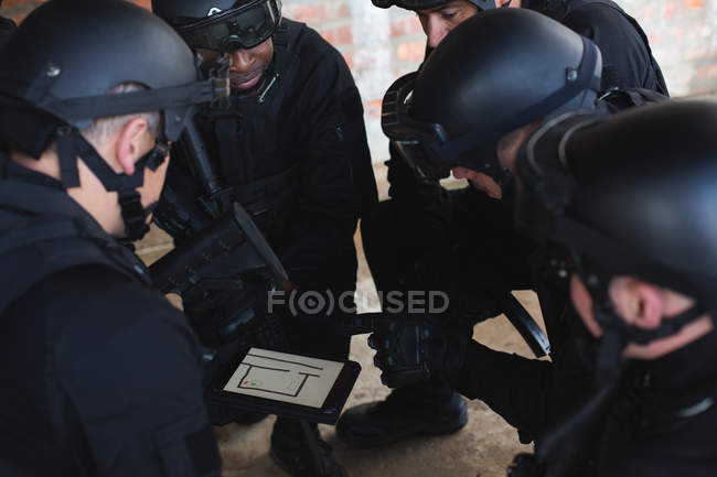 Soldats militaires discutant de leur plan sur tablette numérique pendant l'entraînement militaire — Photo de stock