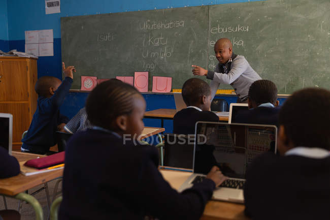 Чоловік вчитель навчає студентів у класі в школі — стокове фото