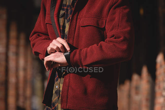 Man using smartwatch on a sunny day during winter — Stock Photo