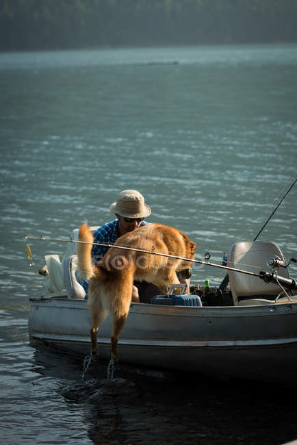 Собака з рибалки на човні в річці — стокове фото