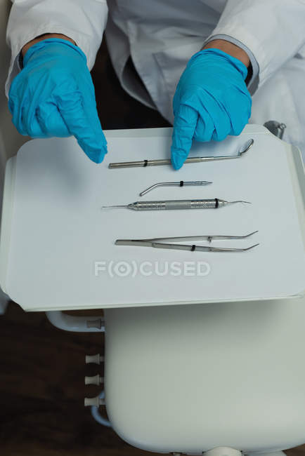 Vista de ángulo alto de herramientas de dentista en bandeja en la clínica - foto de stock