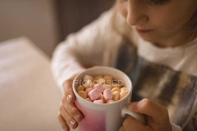 Primo piano della ragazza che guarda i marshmallow nella tazza — Foto stock