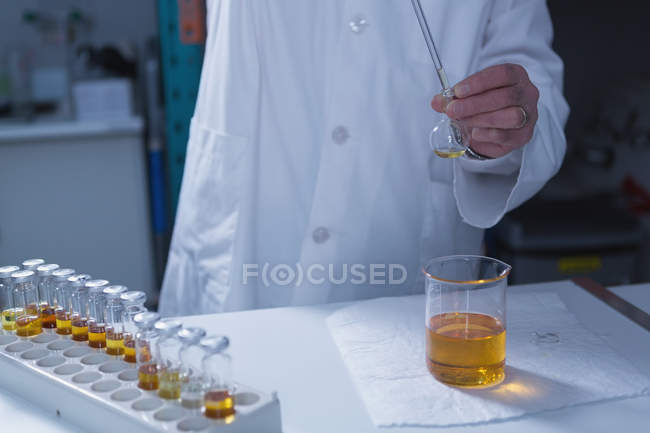 Mid section of male scientist experimenting in laboratory — Stock Photo