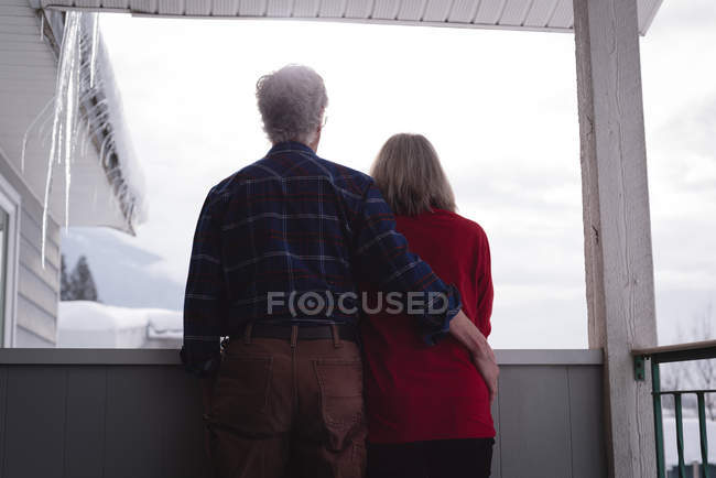 Visão traseira do casal sênior de pé juntos na varanda — Fotografia de Stock