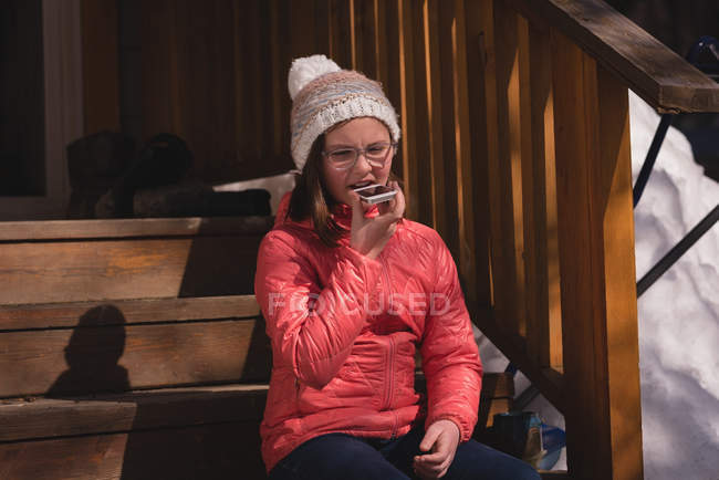 Menina usando telefone celular durante o inverno — Fotografia de Stock