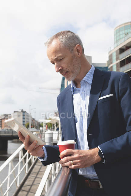Geschäftsmann an einem sonnigen Tag mit digitalem Tablet an der Promenade — Stockfoto