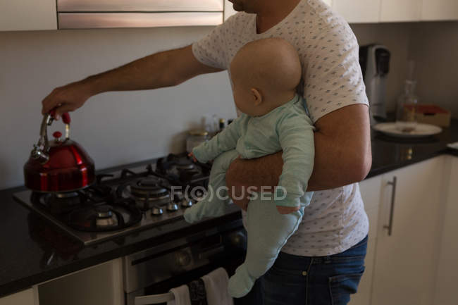 Отец и малыш готовят кофе на кухне дома — стоковое фото