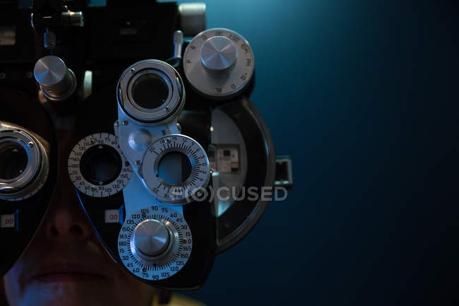 Close-up do optometrista examinando os olhos do paciente com phoropter na clínica — Fotografia de Stock