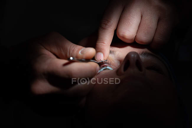 Primo piano dell'optometrista che esamina gli occhi del paziente con apparecchiature per i test oculari in clinica — Foto stock