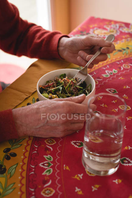 Primer plano del hombre mayor comiendo en casa - foto de stock