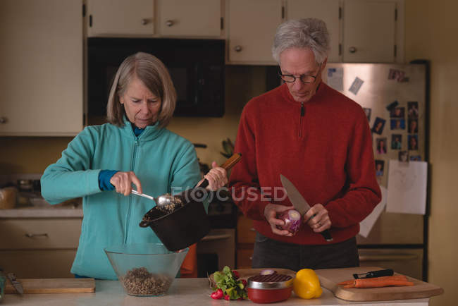 Coppia anziana che prepara il cibo in cucina a casa — Foto stock