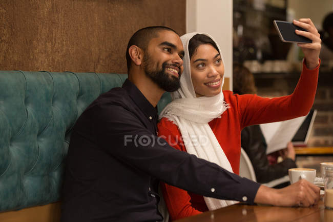 Felice coppia prendendo selfie in caffè — Foto stock