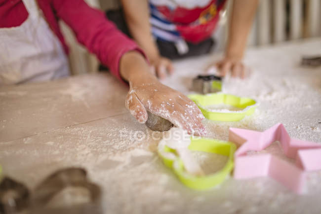 Mid section of siblings cutting cookies — Stock Photo