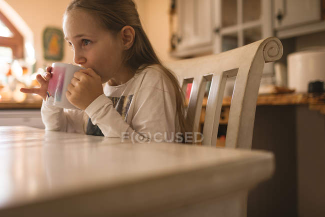 Вид збоку на дівчину, що п'є каву вдома — стокове фото