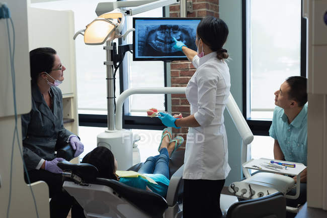 Female dentist explaining dental x-ray report in clinic — Stock Photo