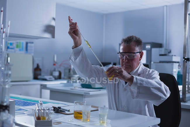 Уважний вчений-чоловік експериментує в лабораторії — стокове фото