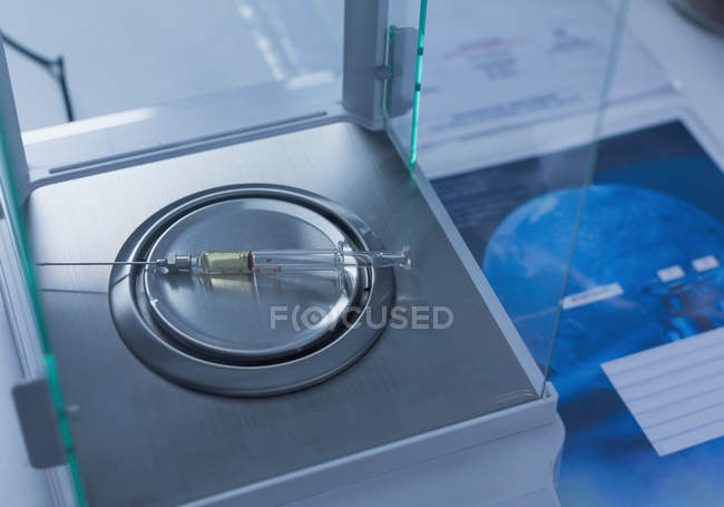 Close-up of syringe on lab weighing scale in laboratory — Stock Photo