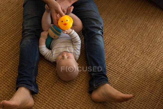 Отец и мальчик играют с игрушками в гостиной дома — стоковое фото