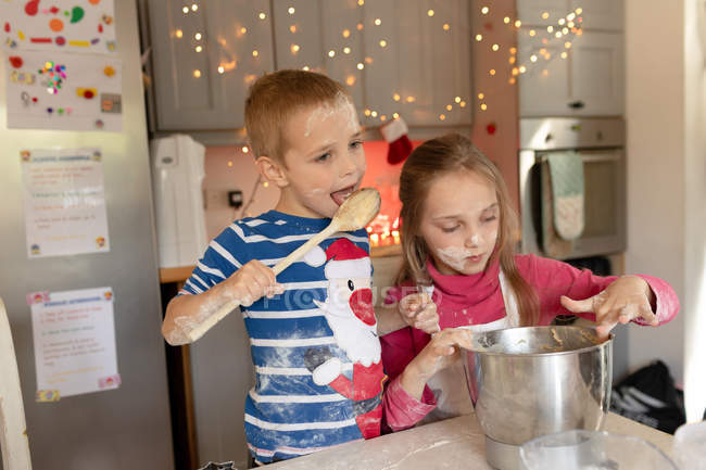 Geschwister bereiten Teig für Weihnachtsplätzchen in der Küche zu — Stockfoto
