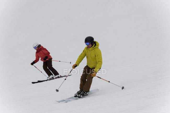 Skier couple skiing on snowy landscape during winter — Stock Photo
