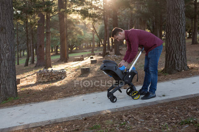 Pai segurando seu menino no parque em um dia ensolarado — Fotografia de Stock