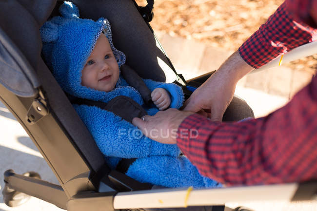 Nahaufnahme des Vaters mit seinem kleinen Jungen im Kinderwagen im Park — Stockfoto