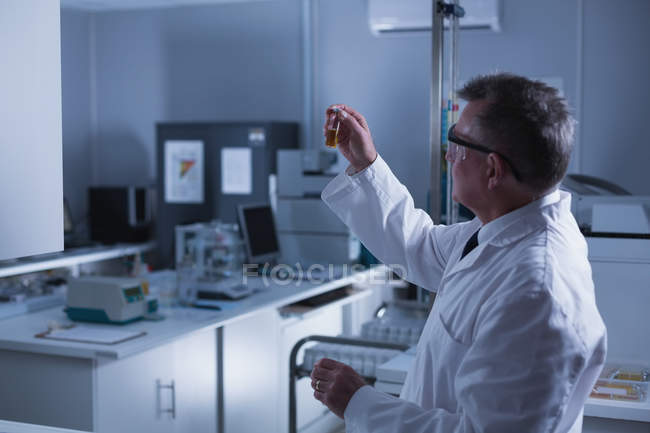 Vista lateral del científico masculino experimentando en laboratorio - foto de stock