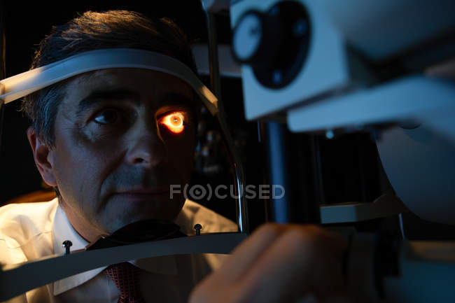 Optometrist examining patient eyes with slit lamp in clinic — Stock Photo